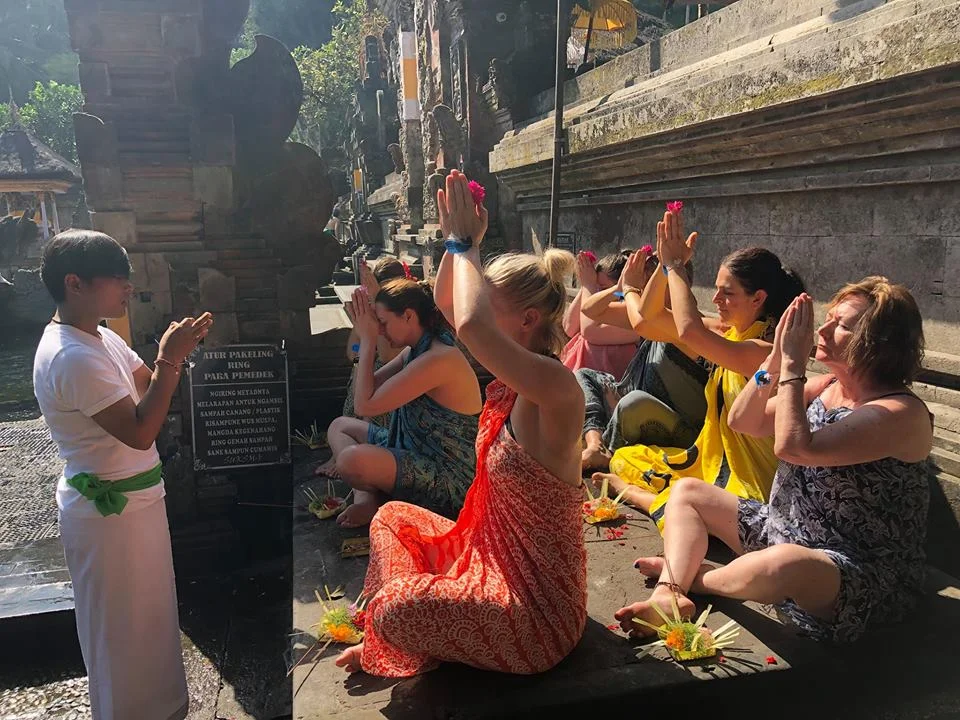 Retreat guests receiving a blessing at a Balinese water temple